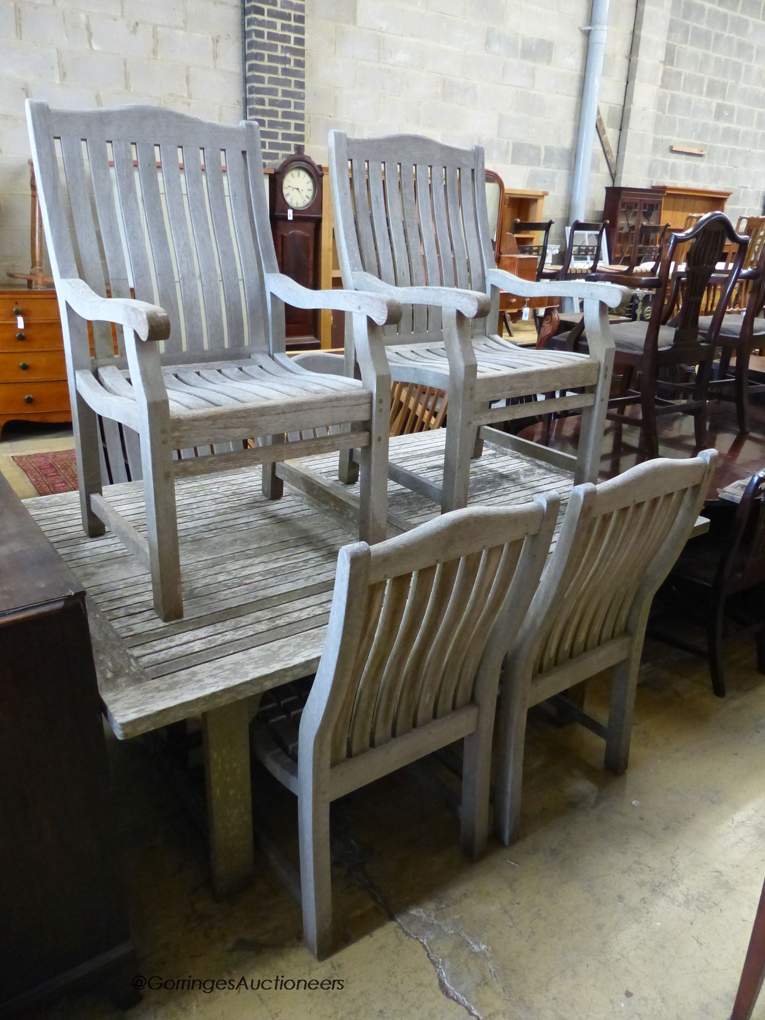 A weathered teak extending dining table, extended 250cm, depth 120cm, height 75cm and six chairs